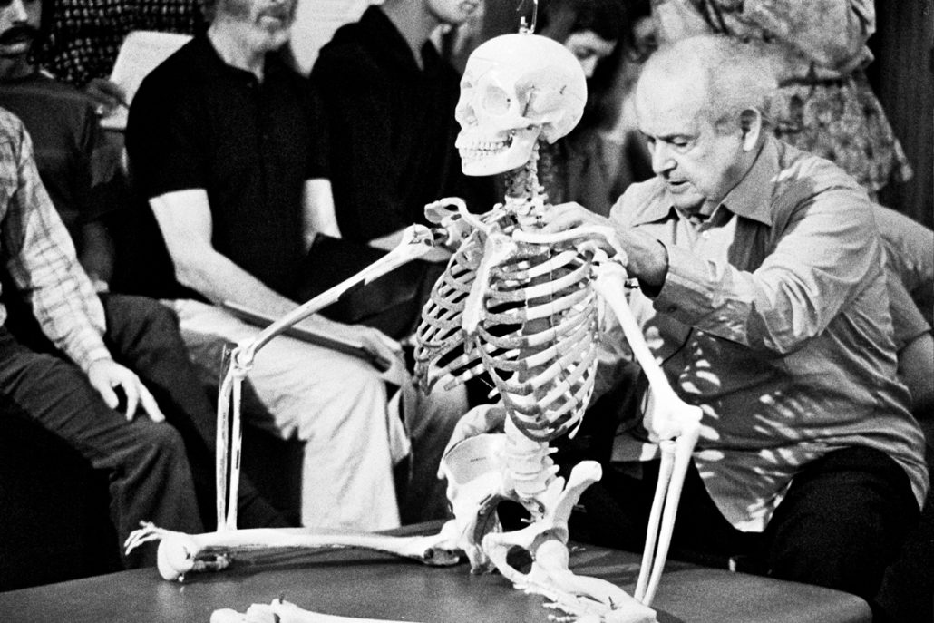 Moshé Feldenkrais enseñando con un esqueleto anatómico